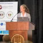 Julia O'Hanlon speaking at the podium during the 2024 Delaware Healthcare Workforce Summit.
