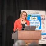 Michelle Washko speaking at the podium during the 2024 Delaware Healthcare Workforce Summit.
